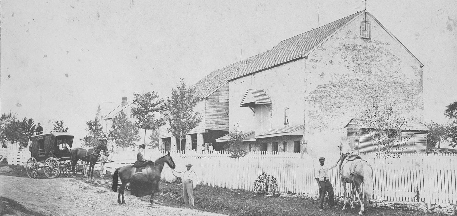 photo of Hannah Davis Saunders on horse back in front of her barn