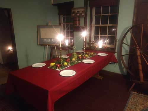 photo of table with red table cloth and senter runner with pears, apples and pineapple