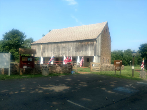 photo of Graeme Park Visitor Center with colonial flags out for 4th Julu 2018