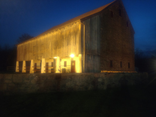 photo of barn at night with forebay in front supported by columns and ramp in rear