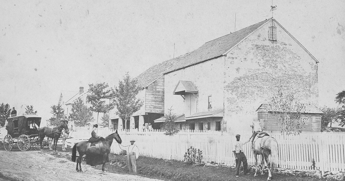 photo of Hannah Davis Saunders on horse back in front of her barn