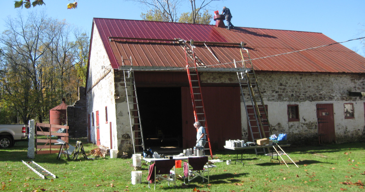 photo fo barn with red roof being repainted